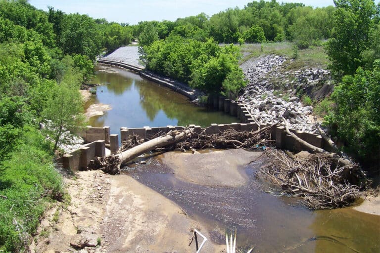 Photo of Berg Oliver Project - Airport Freeway. View of construction site with water, trees, and rubble